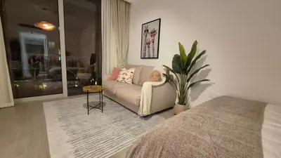 a living room with a couch and a table at Deluxe Studio - Stylish & Cosy in Luma22 in Dubai
