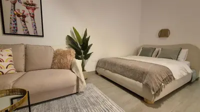 a living room with a couch and a bed at Deluxe Studio - Stylish & Cosy in Luma22 in Dubai