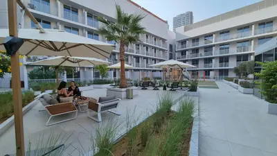 two people sitting on a patio in a building at Deluxe Studio - Stylish & Cosy in Luma22 in Dubai