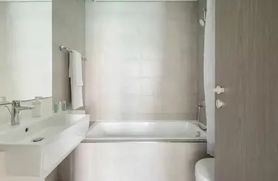 a bathroom with a tub and a sink and a toilet at District one Full Water view Apartment in Dubai