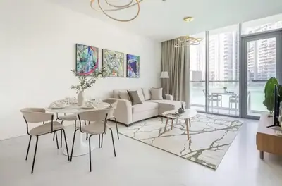 a living room with a couch and a table and chairs at District one Full Water view Apartment in Dubai