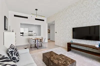a living room with a large flat screen tv on a wall at Stylish 1 Bedroom in Binghatti Lavender JVC in Dubai
