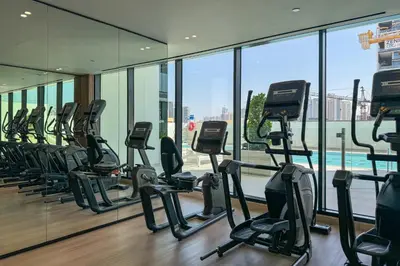 a gym with a row of treadmills in a building at Stylish 1 Bedroom in Binghatti Lavender JVC in Dubai