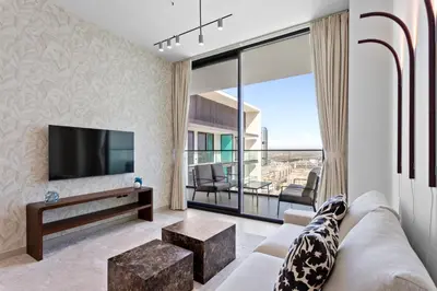 a living room with a couch and a tv at Stylish 1 Bedroom in Binghatti Lavender JVC in Dubai