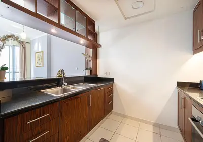 a kitchen with wooden cabinets and a sink at Stunning 2 BR Burj Khalifa Fountain Views in Dubai