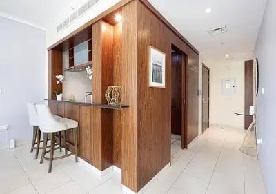 a kitchen with a wooden wall and a bar at Stunning 2 BR Burj Khalifa Fountain Views in Dubai