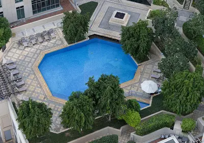 an overhead view of a swimming pool with trees and chairs at Stunning 2 BR Burj Khalifa Fountain Views in Dubai