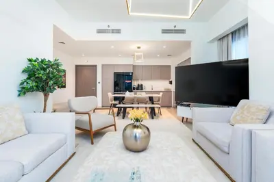 a living room with white furniture and a flat screen tv at Westminster ACT1 ACT2 Burj Khalifa in Dubai