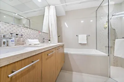 a bathroom with a tub and a sink and a shower at 2BR plus Maid Bellevue Tower 1, Burj Khalifa View in Dubai