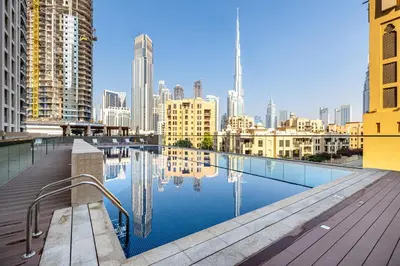 a swimming pool with a city skyline in the background at 2BR plus Maid Bellevue Tower 1, Burj Khalifa View in Dubai