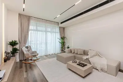 a white living room with a couch and a chair at Heart of Dubai in Dubai