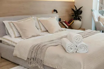 a white bed with two towels on top of it at Heart of Dubai in Dubai