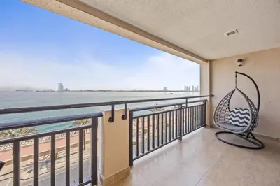 a balcony with a hammock and a view of the ocean at Burj View Luxury 1BR - Full Sea View Private Beach - Anantara Palm in Dubai