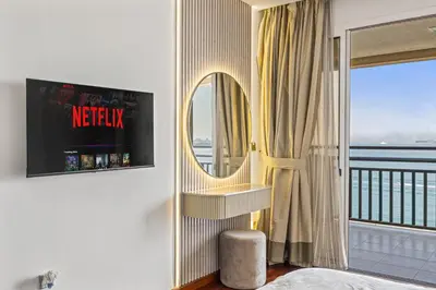 a bedroom with a mirror and a balcony at Burj View Luxury 1BR - Full Sea View Private Beach - Anantara Palm in Dubai