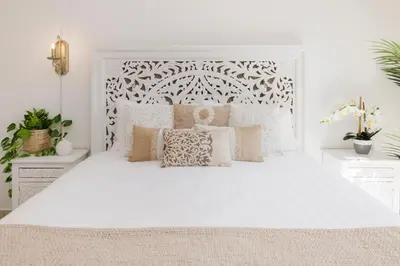 a white bedroom with a large white bed with pillows at 1001 Nights - Luxury 1-BR apartment near Burj in Dubai