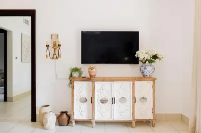 a living room with a television on a white wall at 1001 Nights - Luxury 1-BR apartment near Burj in Dubai