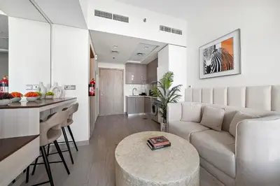 a living room and kitchen with a couch and a table at Studio Azizi Riviera 35, Community View in Dubai