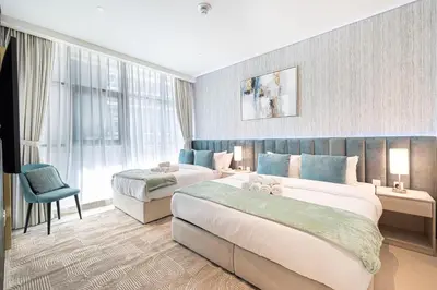 a hotel room with two beds and a window at Palm Jumeirah - Private Beach & Free Infinity Pool in Dubai