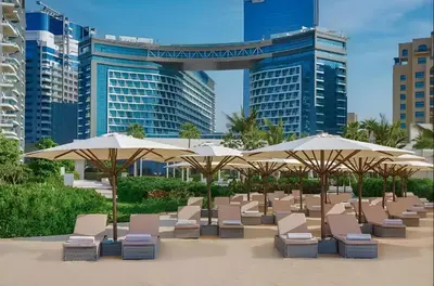 a row of chairs and umbrellas in front of buildings at Palm Jumeirah - Private Beach & Free Infinity Pool in Dubai