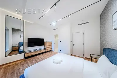 a bedroom with a large white bed and a tv at Jumeirah Beach Residence - Rimal 6, Dubai Marina in Dubai