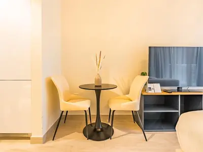 a table with two chairs and a desk with a computer at Tranquil Studio Getaway in Meydan City in Dubai