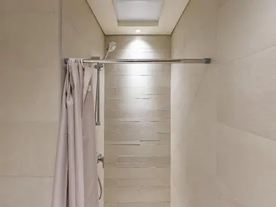 a shower with a shower curtain in a bathroom at Tranquil Studio Getaway in Meydan City in Dubai