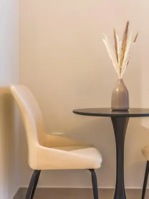 a table with a chair and a table with a vase at Tranquil Studio Getaway in Meydan City in Dubai