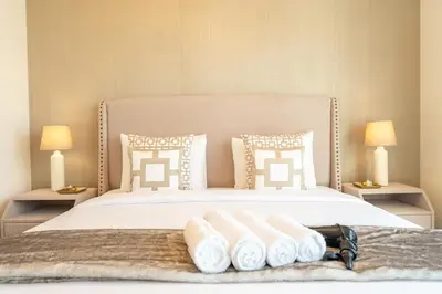 a bedroom with a large white bed with towels on it at Luxury Apartment in the Heart of Downtown Dubai in Dubai