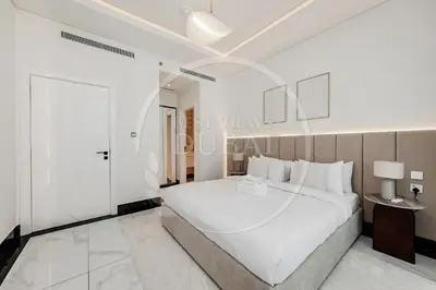 a white bedroom with a large bed and a glass door at Luxury 2Bdr Apartment in Business Bay in Dubai