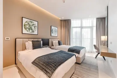 a hotel room with two beds and a desk at Modern 2-Bedroom Apartment Near Burj Khalifa & Dubai Mall in Dubai