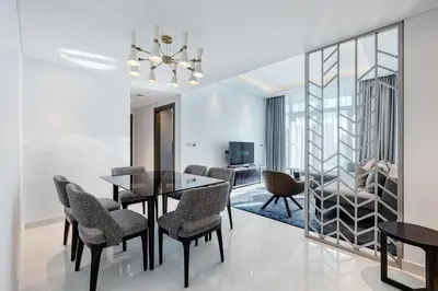 a dining room and living room with a dining table and chairs at Modern 2-Bedroom Apartment Near Burj Khalifa & Dubai Mall in Dubai