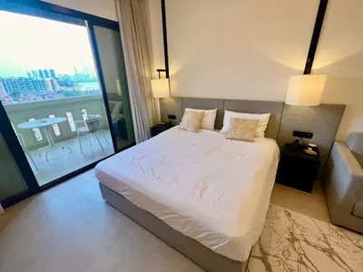 a bedroom with a white bed and a large window at Palm Jumeirah, Studio, Fantastischer Meer-, Beach- und Skyline Blick, Strand in Dubai