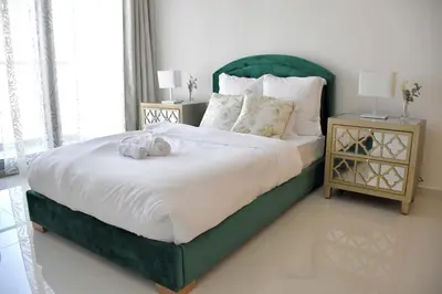 a bedroom with a large bed with a green headboard at Luxury Dubai High Rise, Skyline Views in Dubai