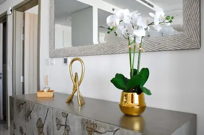 a table with a vase of flowers and a mirror at Luxury Dubai High Rise, Skyline Views in Dubai