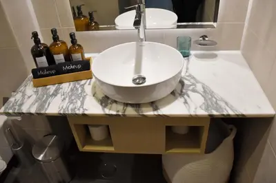 a bathroom counter with a sink and two bottles of wine at Luxury Dubai High Rise, Skyline Views in Dubai