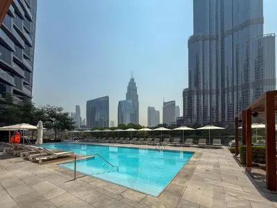 a large pool with chairs and umbrellas in a city at Frank Porter - Address Opera in Dubai