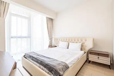 a bedroom with a large white bed with a window at Superhost - Bright & Stylish 1-Bedroom in Bloom Tower, JVC in Dubai