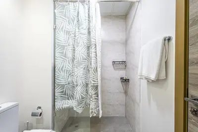 a bathroom with a shower with a shower curtain at Superhost - Bright & Stylish 1-Bedroom in Bloom Tower, JVC in Dubai