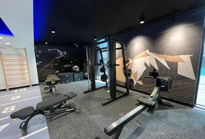 a gym with cardio equipment and a painting of an umbrella at HAVN - 1 Bedroom in Harrington House, JVC in Dubai