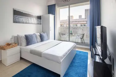 a bedroom with a bed and a tv and a window at Frank Porter - Hanover Square in Dubai