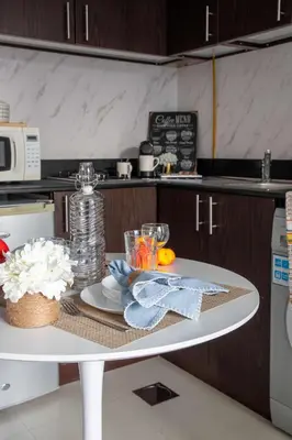 a white table in a kitchen with a counter top at Frank Porter - Hanover Square in Dubai