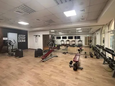 a gym with a lot of treadmills and weights at Frank Porter - Hanover Square in Dubai