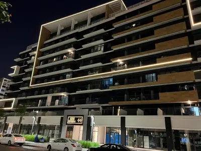 a large building with cars parked in front of it at Special Offer Rental One Bedroom Apartment at Azizi Riviera Dubai in Dubai