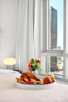 a tray with a plate of food on a bed at Trendy 2BR Direct Mall Access Burj View High Floor in Dubai