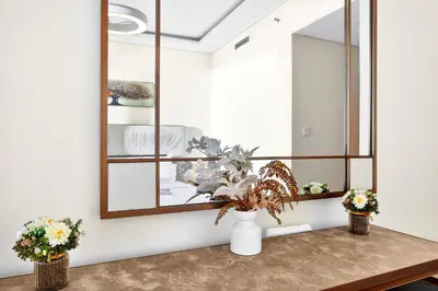 a room with a mirror and a table with flowers at Trendy 2BR Direct Mall Access Burj View High Floor in Dubai