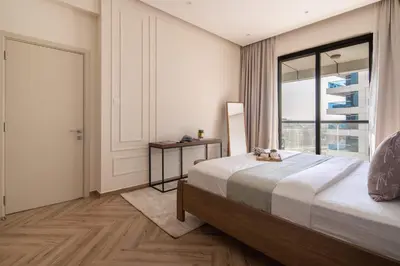 a bedroom with a bed and a large window at Frank Porter - Escan Tower in Dubai