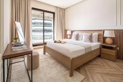 a bedroom with a bed and a desk and a window at Frank Porter - Escan Tower in Dubai
