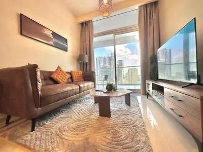 a living room with a couch and a large television at Sleek & Spacious 2BR in DAMAC Vera, Business Bay by Bhavan Vacation Homes in Dubai
