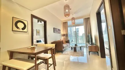 a living room with a table and a couch at Sleek & Spacious 2BR in DAMAC Vera, Business Bay by Bhavan Vacation Homes in Dubai