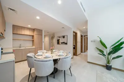 a kitchen and dining room with a table and chairs at Modern 2BR Canal-Side Elegance in Dubai